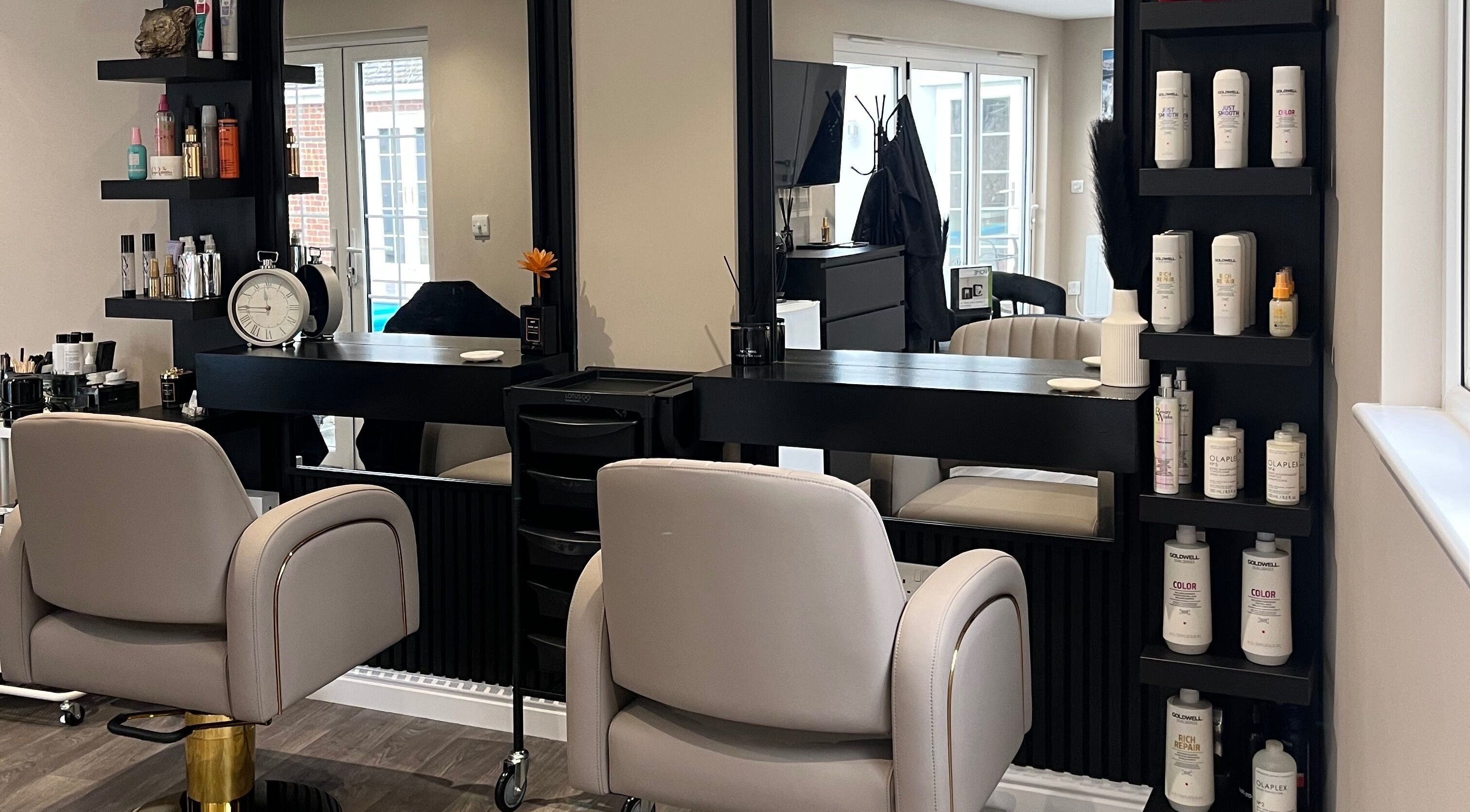 Chic salon setup at Hair by Tia in Stanway, England, GB with cozy chairs and shelves of premium hair products.