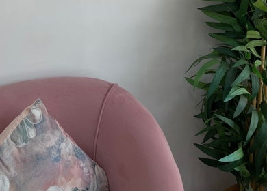 Elegant pink chair with decorative pillow at Beauty By B, Roodepoort, Gauteng, ZA. Inviting ambiance for relaxation.