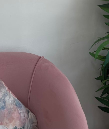 Elegant pink chair with decorative pillow at Beauty By B, Roodepoort, Gauteng, ZA. Inviting ambiance for relaxation.