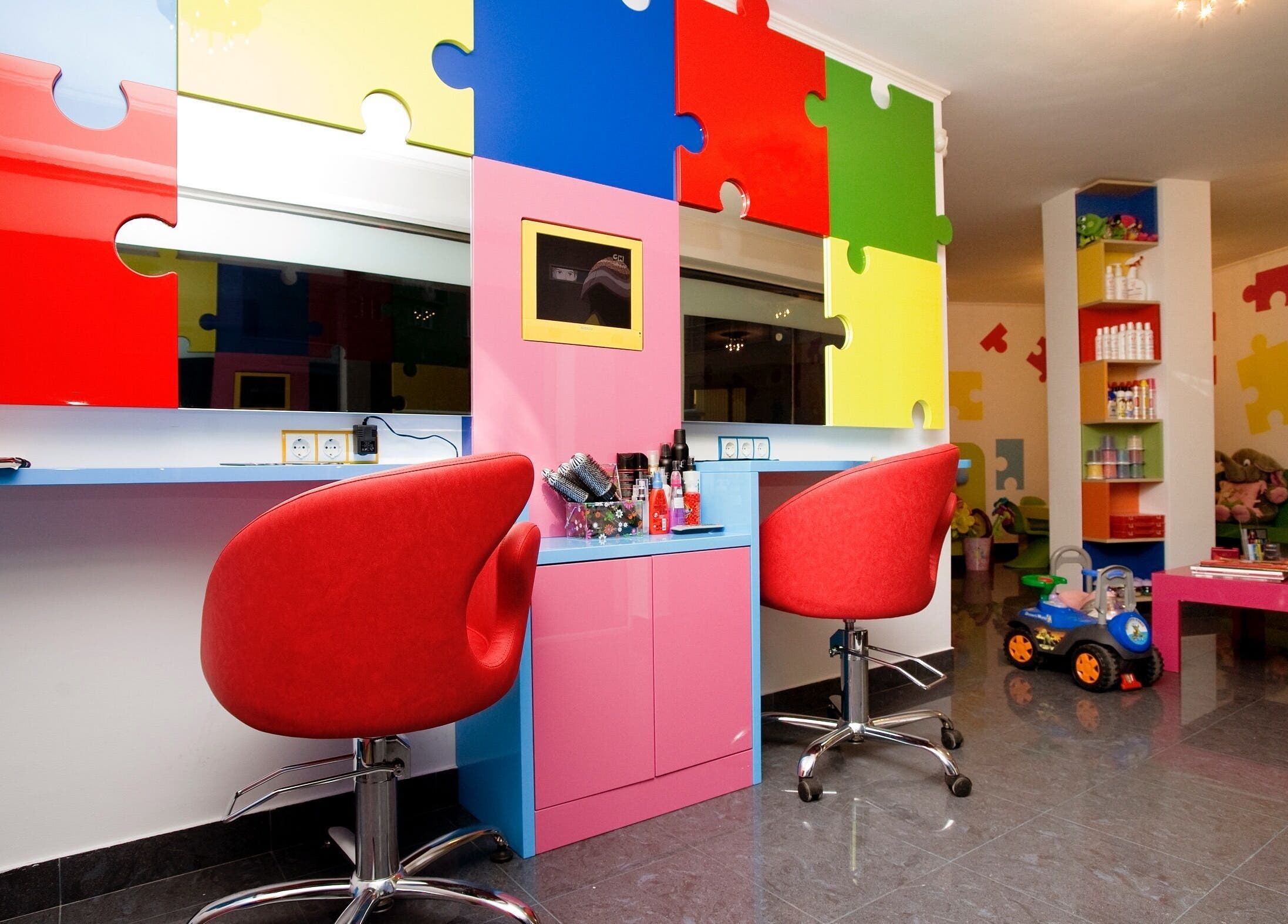 Ярко оцветена стая в ПЪЗЕЛ София кв. Дружба, София, BG с пъзел стени и червени столове.