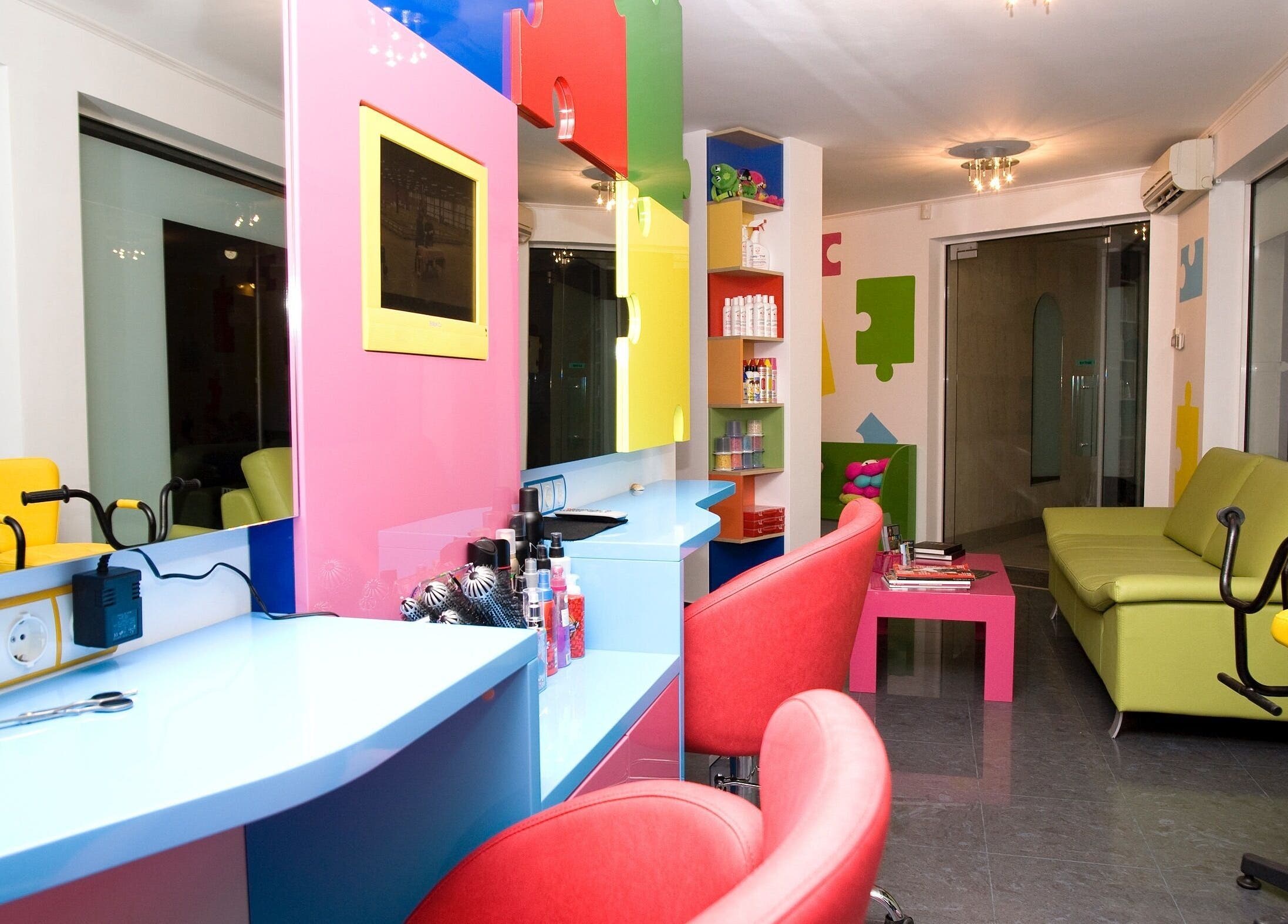 Ярко обзаведен салон на ПЪЗЕЛ София кв. Дружба, София, BG с червени кресла и зелени дивани.