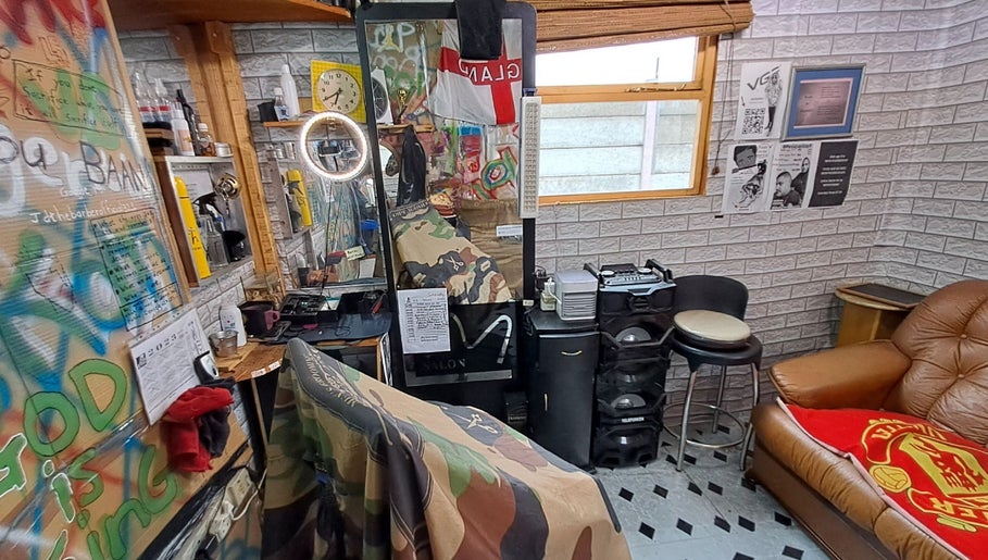 Eclectic barbershop interior at Jd Cuts, Cape Town, Western Cape, ZA, featuring a graffiti-styled wall and cozy seating.