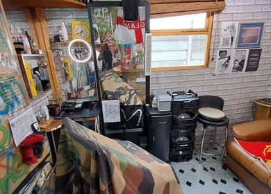 Eclectic barbershop interior at Jd Cuts, Cape Town, Western Cape, ZA, featuring a graffiti-styled wall and cozy seating.