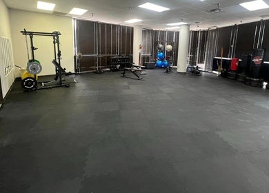 Spacious gym area at Warrior’s Edge in Dallas, Texas, US featuring workout equipment and mats.