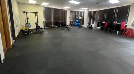 Spacious gym area at Warrior’s Edge in Dallas, Texas, US featuring workout equipment and mats.