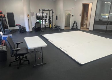Spacious gym training area at Warrior’s Edge, Dallas, Texas, US, featuring fitness mats and equipment.