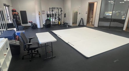 Spacious gym training area at Warrior’s Edge, Dallas, Texas, US, featuring fitness mats and equipment.