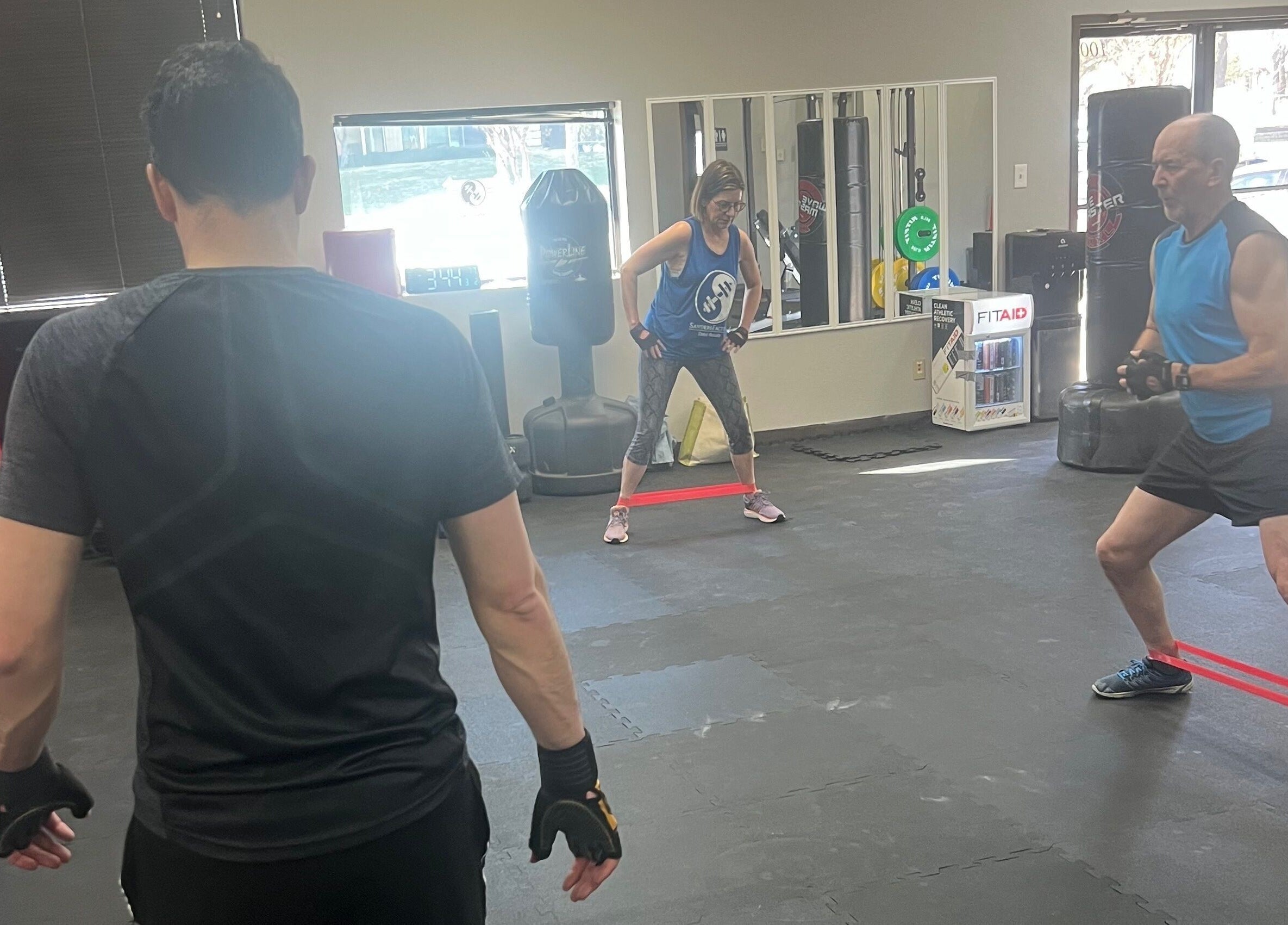 Group fitness training at Warrior’s Edge in Dallas, Texas, US with resistance bands and trainers.