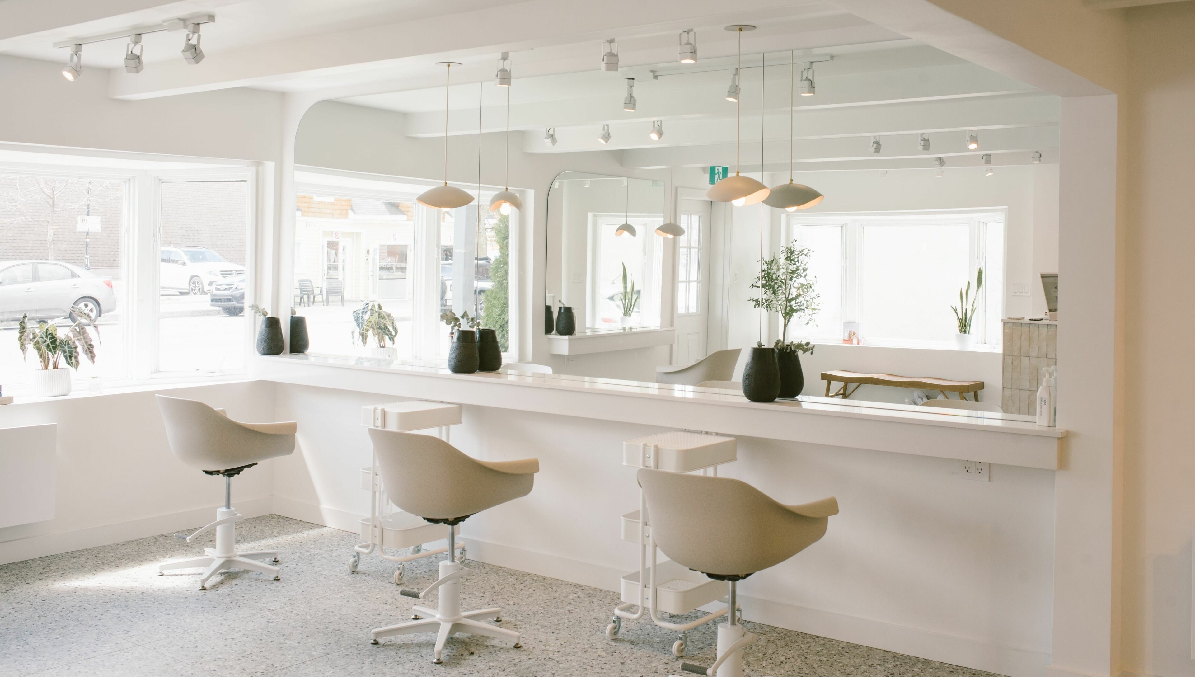 Intérieur moderne et lumineux de Mane by TK à Pointe-Claire, Québec, CA, avec chaises blanches.