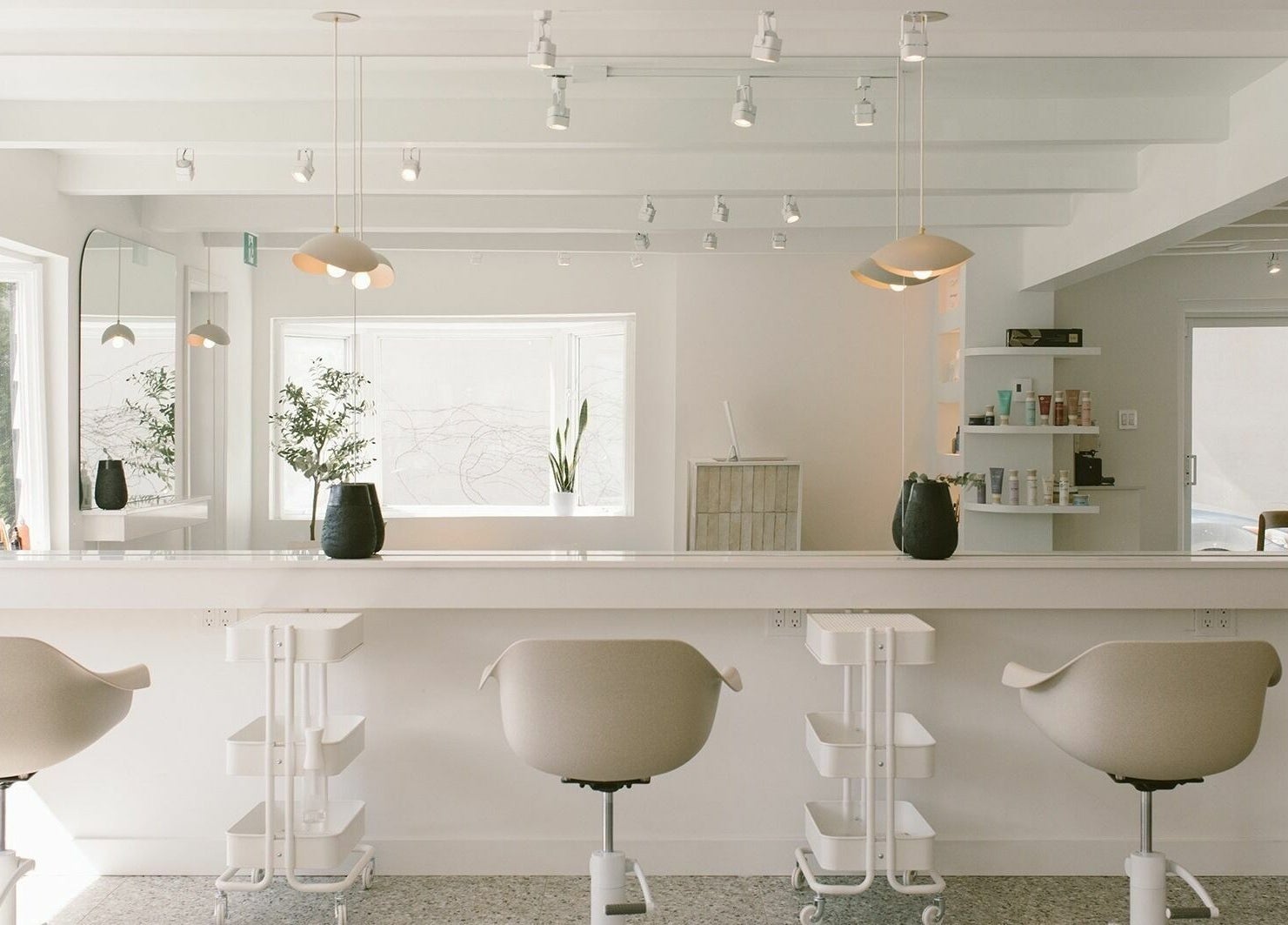 Intérieur moderne du salon Mane by TK à Pointe-Claire, Québec, CA avec chaises blanches élégantes.