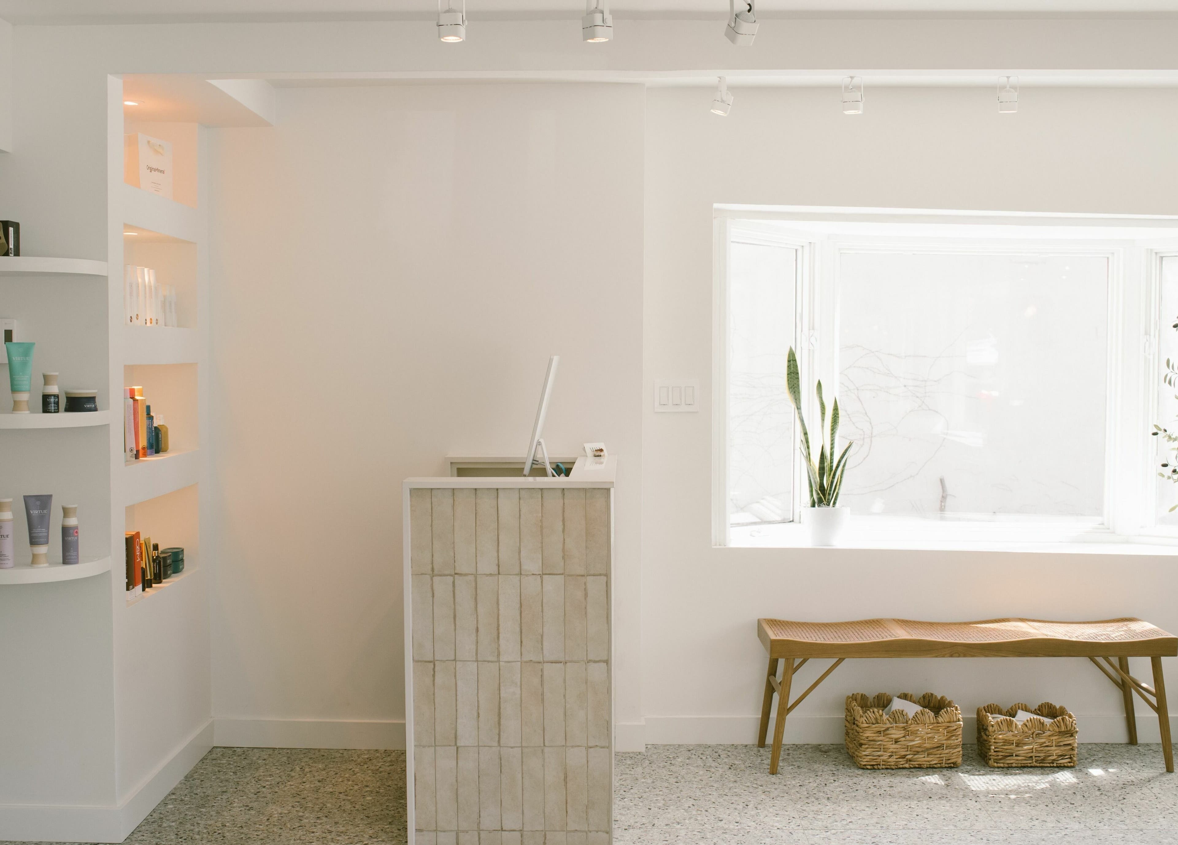 Intérieur lumineux de Mane by TK, Pointe-Claire, Québec, CA, avec comptoir moderne et étagères de produits.