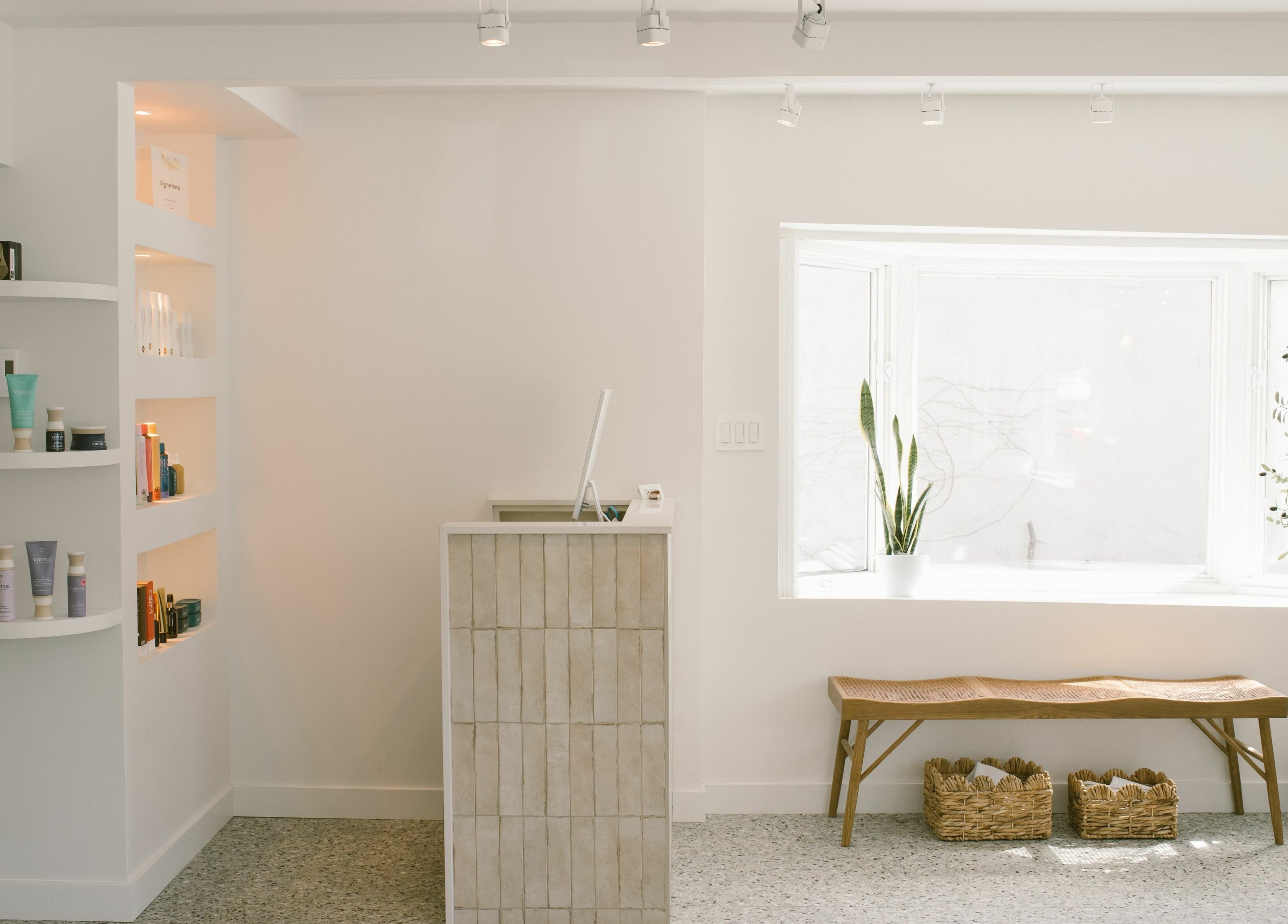 Intérieur lumineux de Mane by TK, Pointe-Claire, Québec, CA, avec comptoir moderne et étagères de produits.