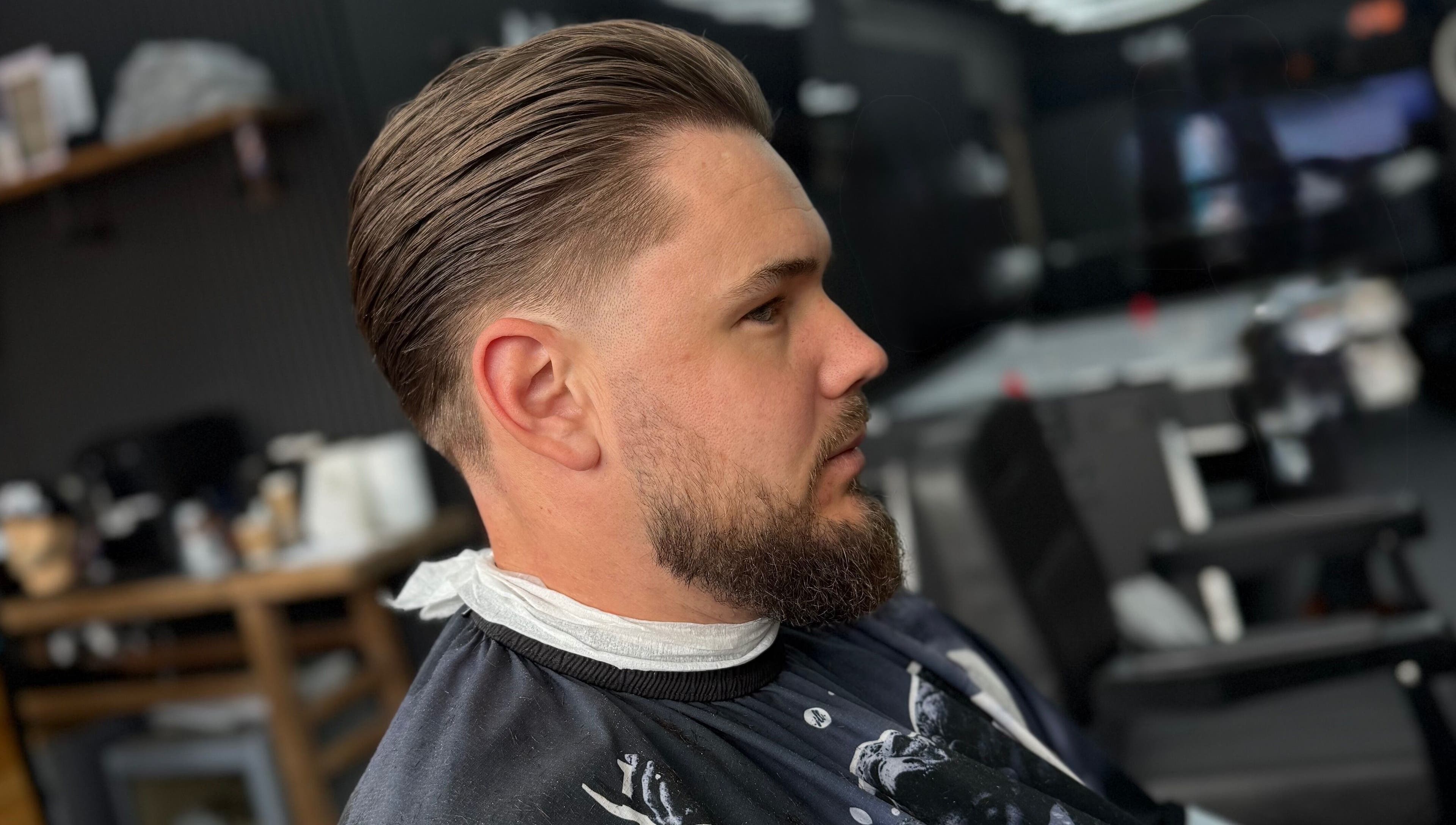 Side view of a man with sleek haircut at Eydmanns Barbering, Bognor Regis, England, GB.