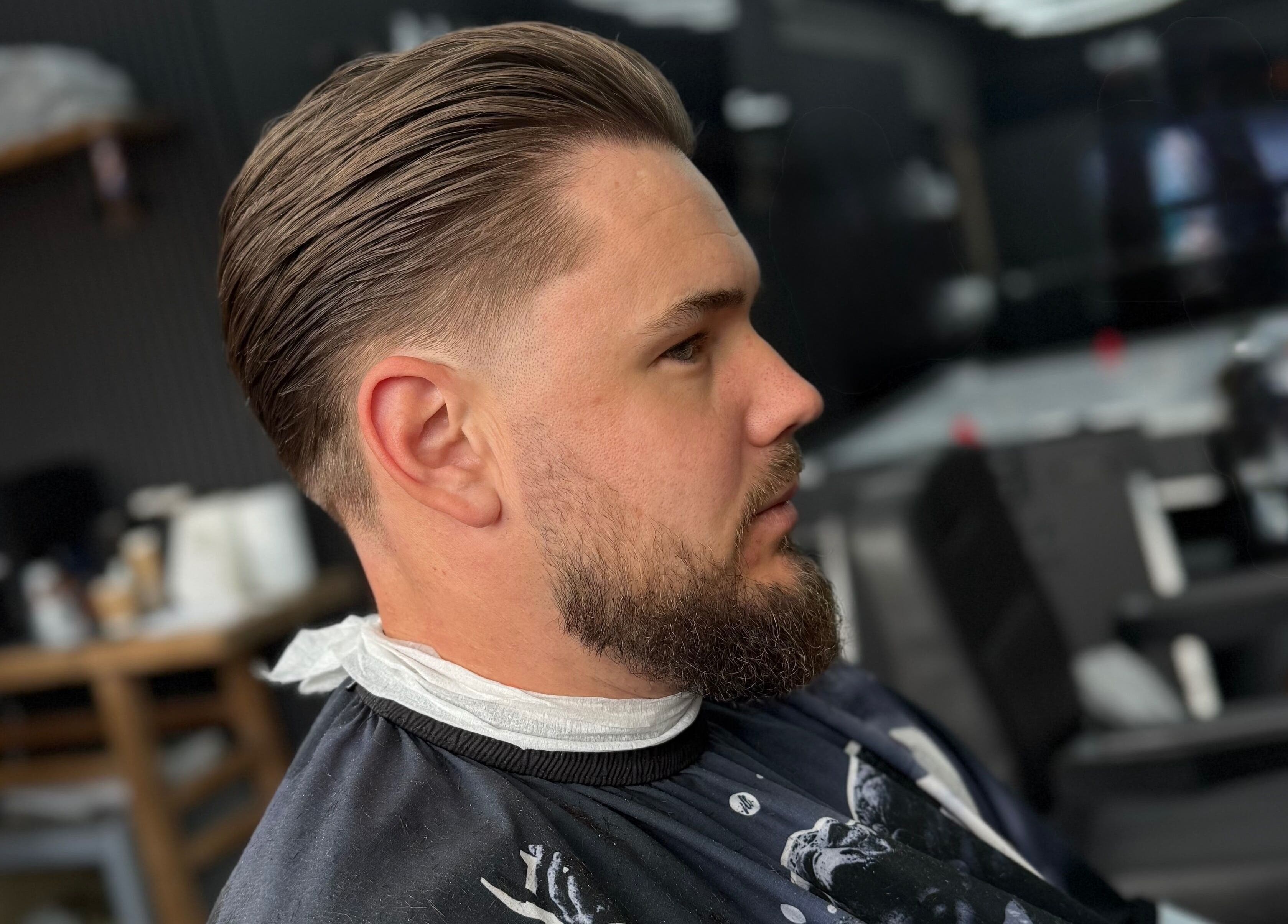Side view of a man with sleek haircut at Eydmanns Barbering, Bognor Regis, England, GB.