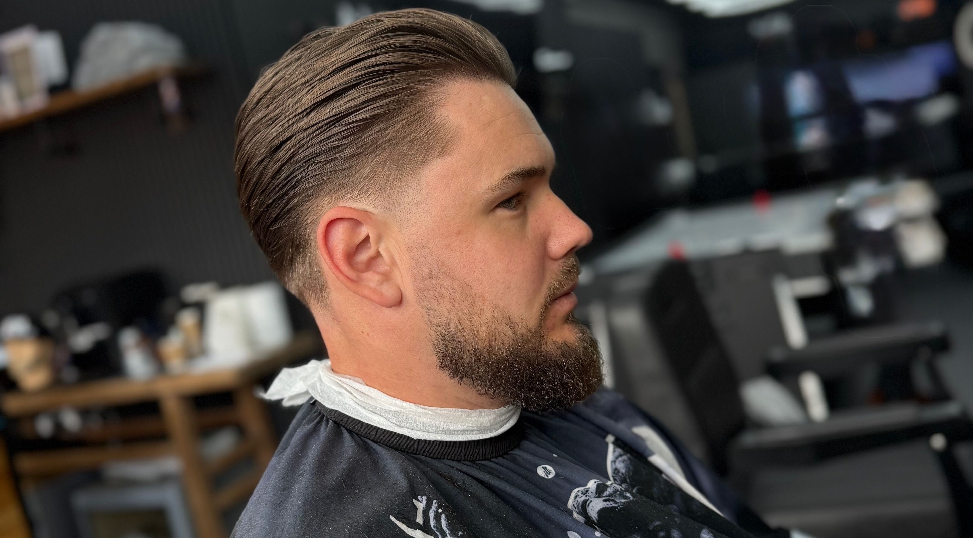 Side view of a man with sleek haircut at Eydmanns Barbering, Bognor Regis, England, GB.