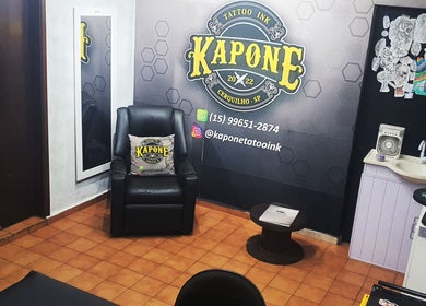 Interior do Kapone Tattoo Ink, São Paulo, SP, com cadeira de tatuagem e decoração artística.