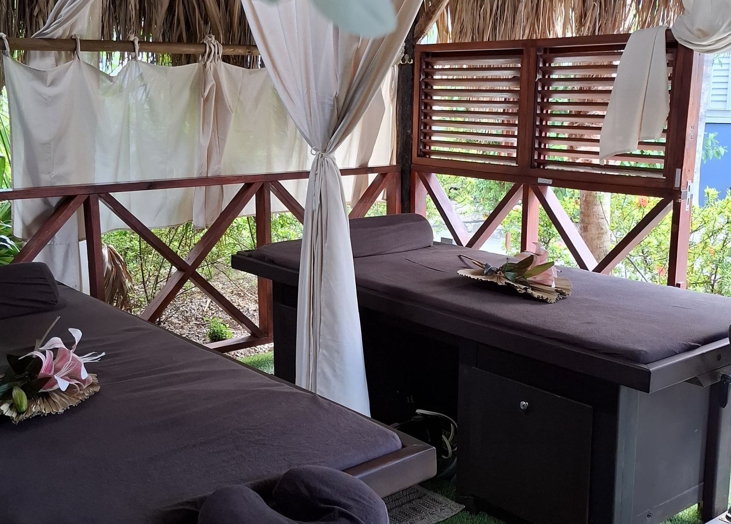 Outdoor massage beds at I-Relax Massages in Willemstad, CW offering a tranquil tropical retreat.