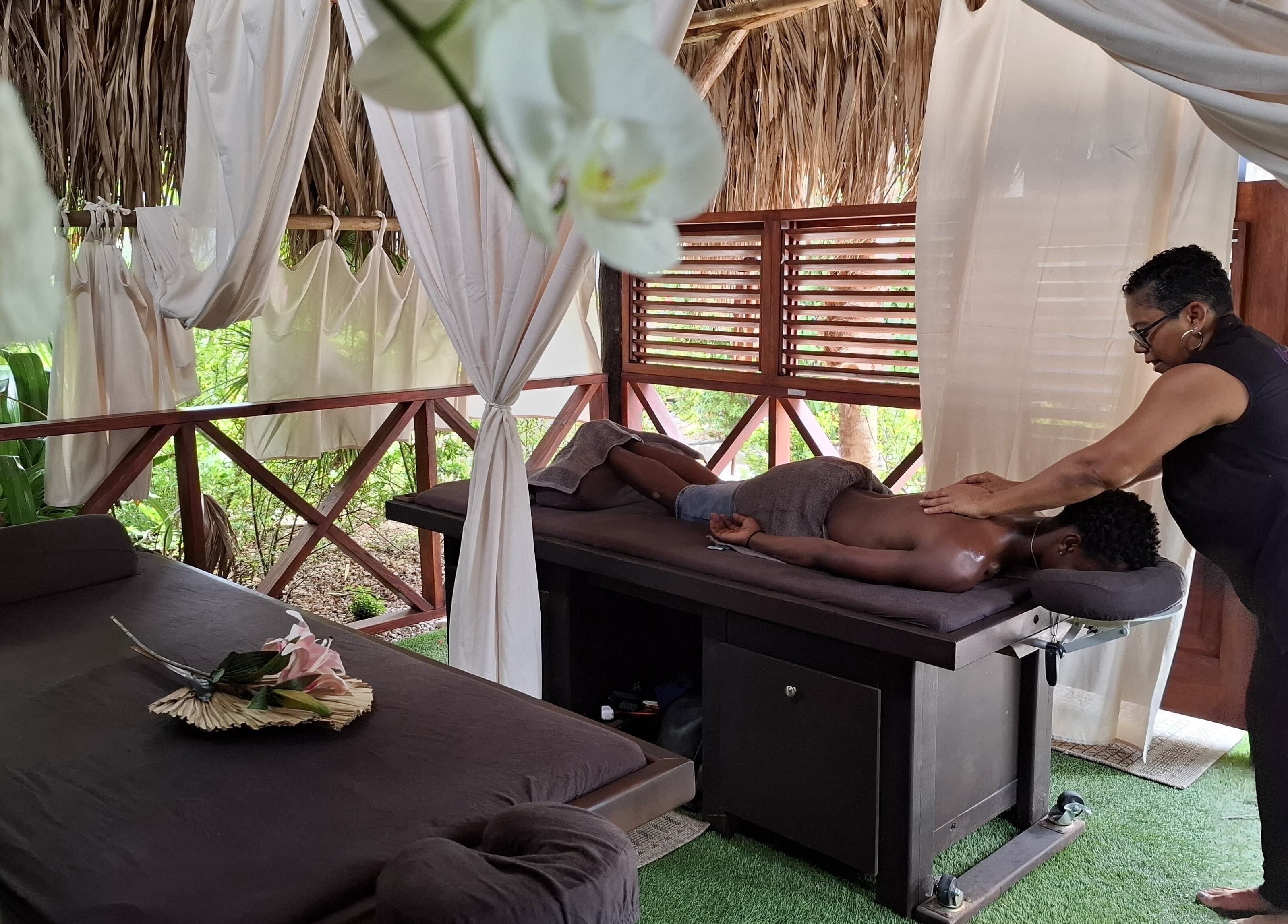 Relaxing massage at I-Relax Massages, Willemstad, CW in a serene outdoor setting with gentle lighting.