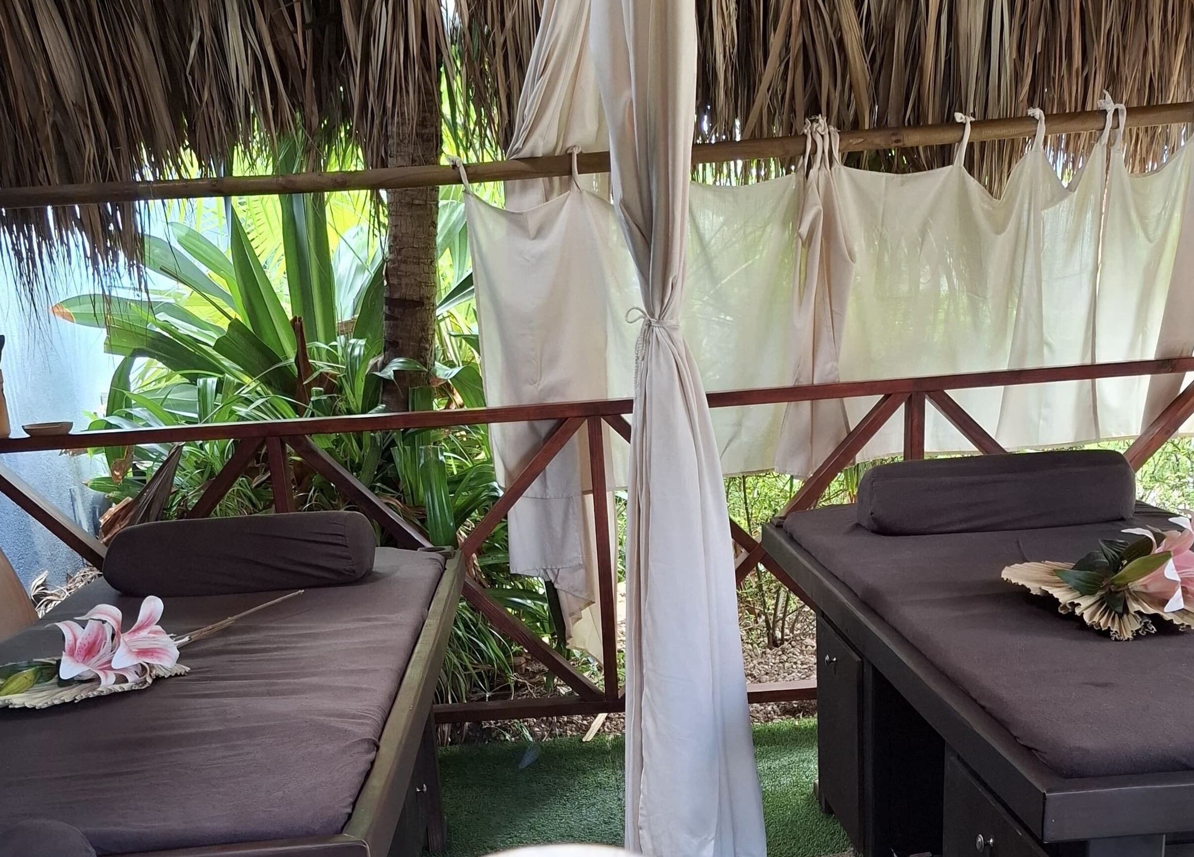 Open-air massage area at I-Relax Massages, Willemstad, CW, featuring tropical decor and lush greenery.