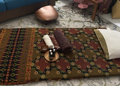 Traditional massage setup at MassageByEllisaBahrin, Selangor, MY, featuring towels and oils.