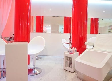 Sleek interior of Nailstation in Dubai, AE with modern chairs and vibrant red accents.