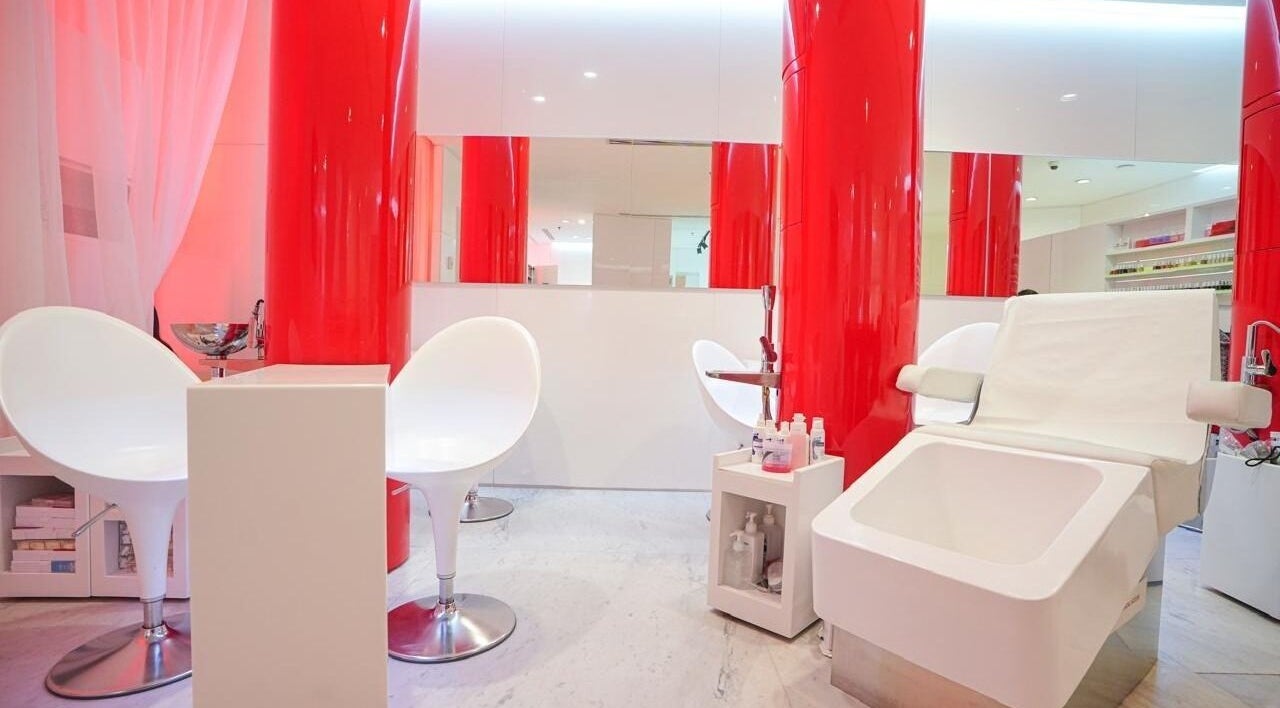 Sleek interior of Nailstation in Dubai, AE with modern chairs and vibrant red accents.