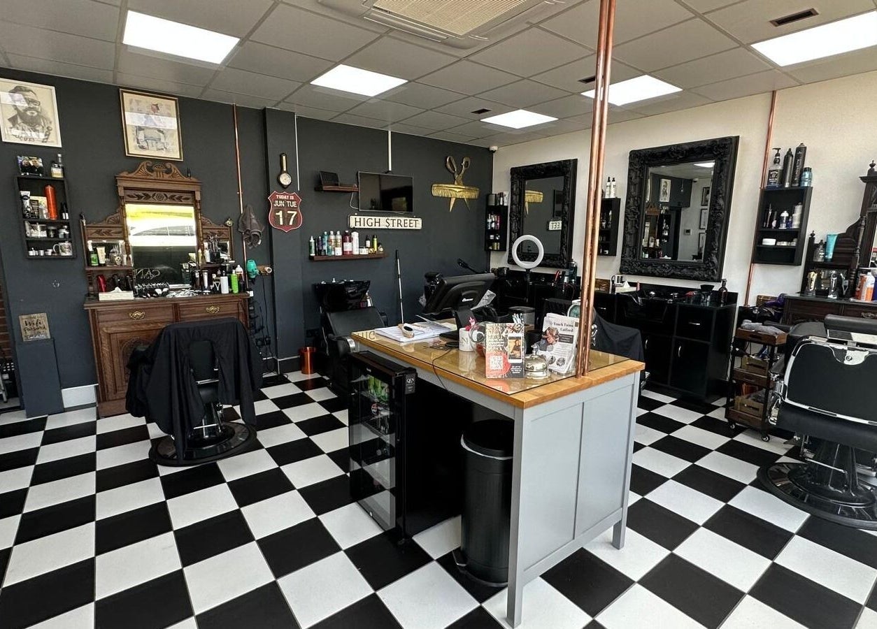 Interior of Can Cuts in Orpington, England, GB showcasing vintage barber chairs and checkerboard flooring.
