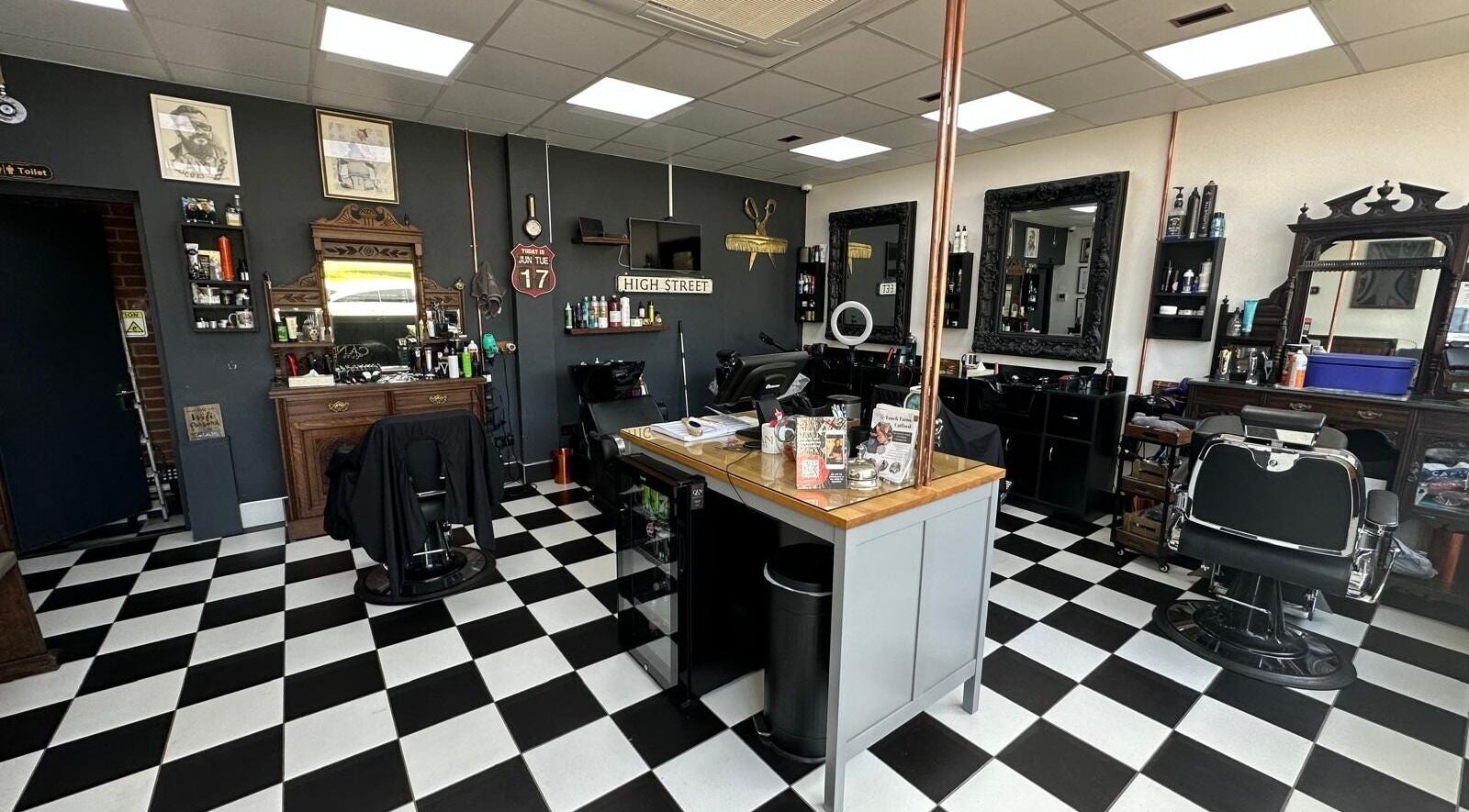 Interior of Can Cuts in Orpington, England, GB showcasing vintage barber chairs and checkerboard flooring.
