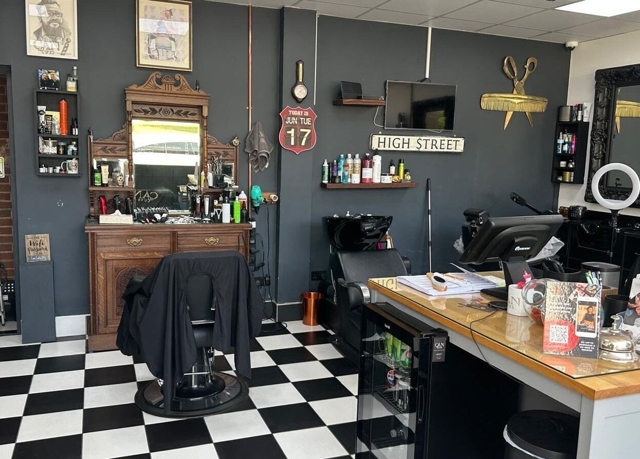 Interior of Can Cuts, Orpington, England, GB showcasing vintage-style barber decor with mirrors and styling chair.