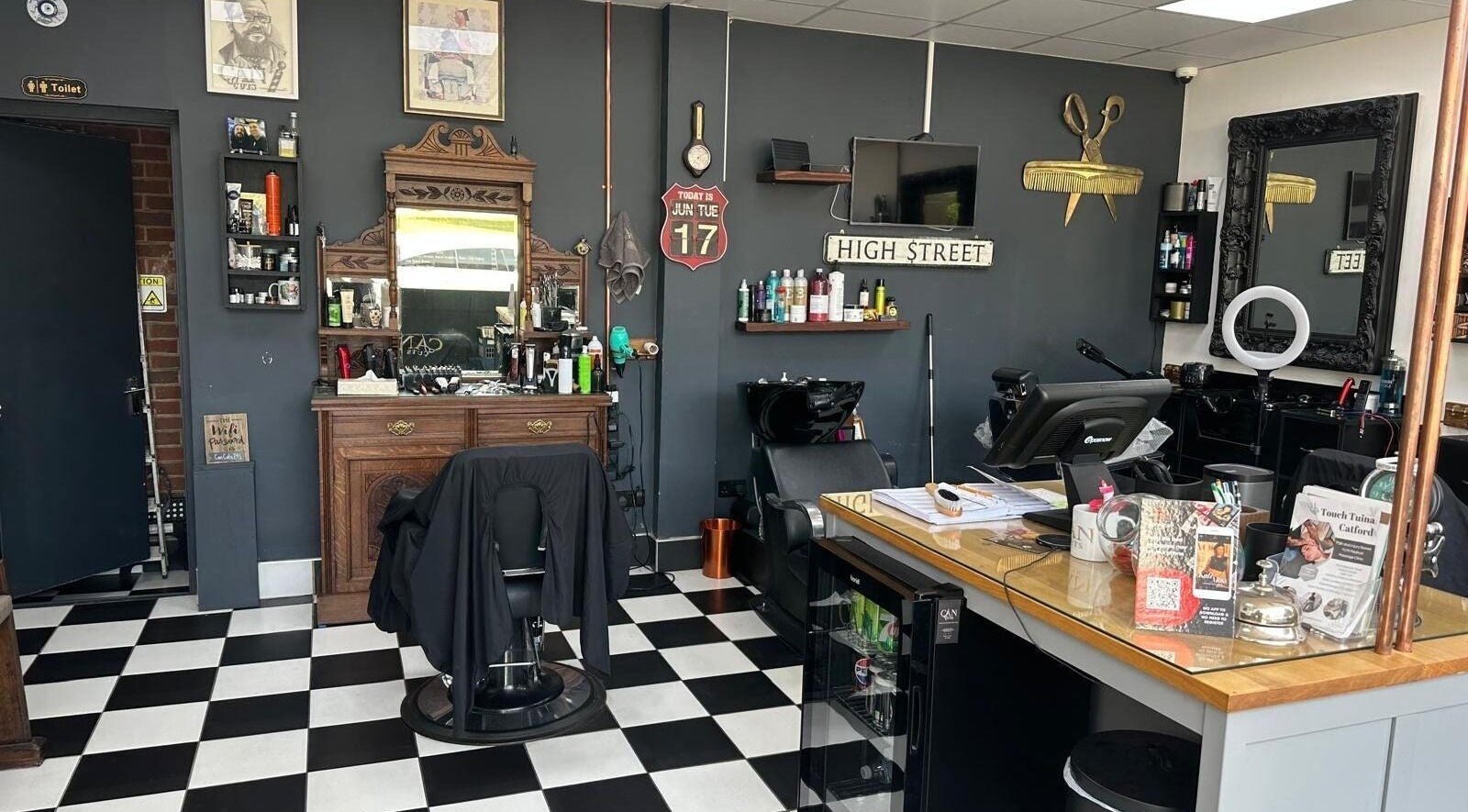 Interior of Can Cuts, Orpington, England, GB showcasing vintage-style barber decor with mirrors and styling chair.