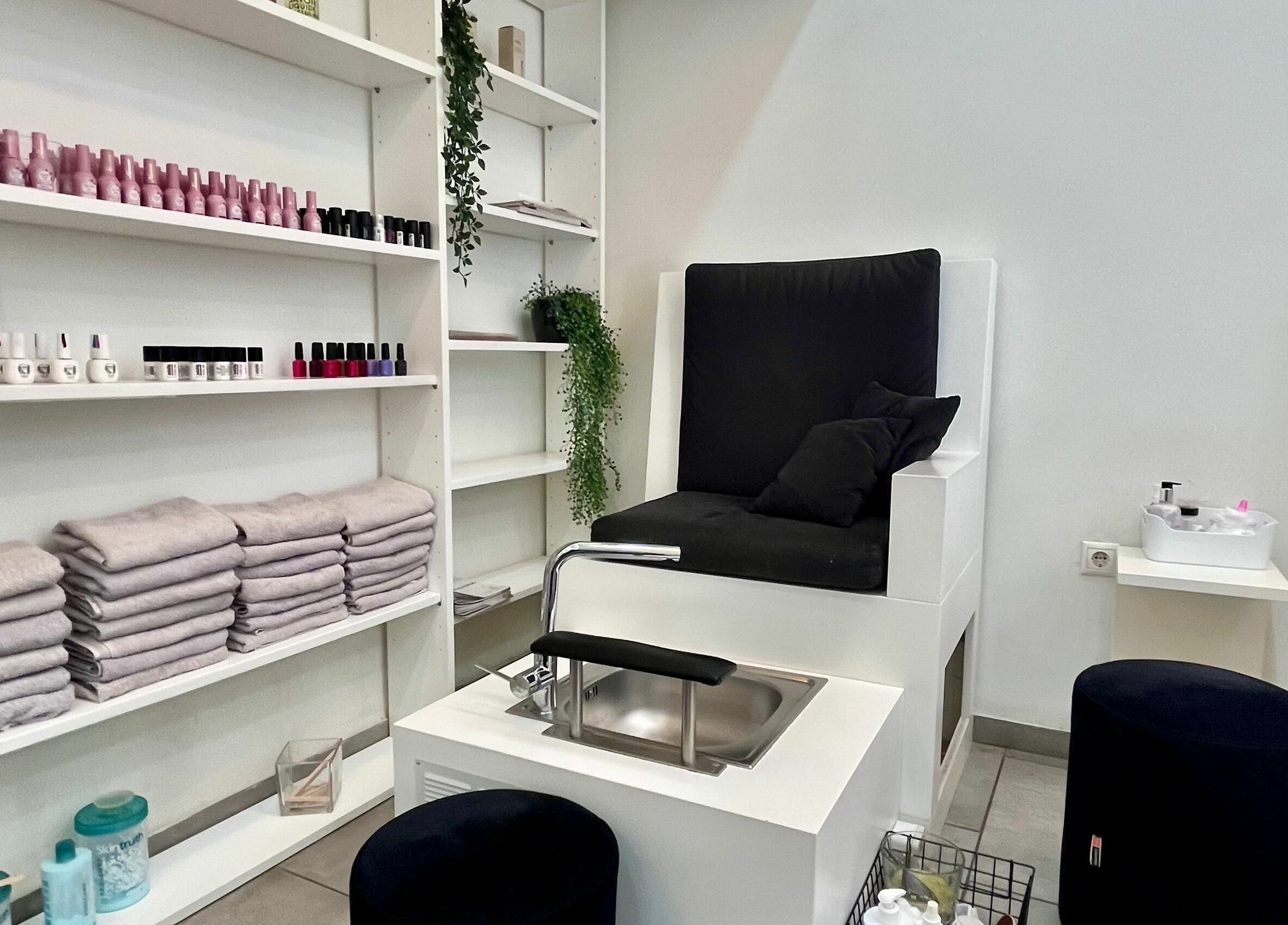 Καλαίσθητος χώρος μανικιούρ και πεντικιούρ στο Y2nails, Αθήνα, GR με κομψά έπιπλα και ποικιλία προϊόντων περιποίησης.