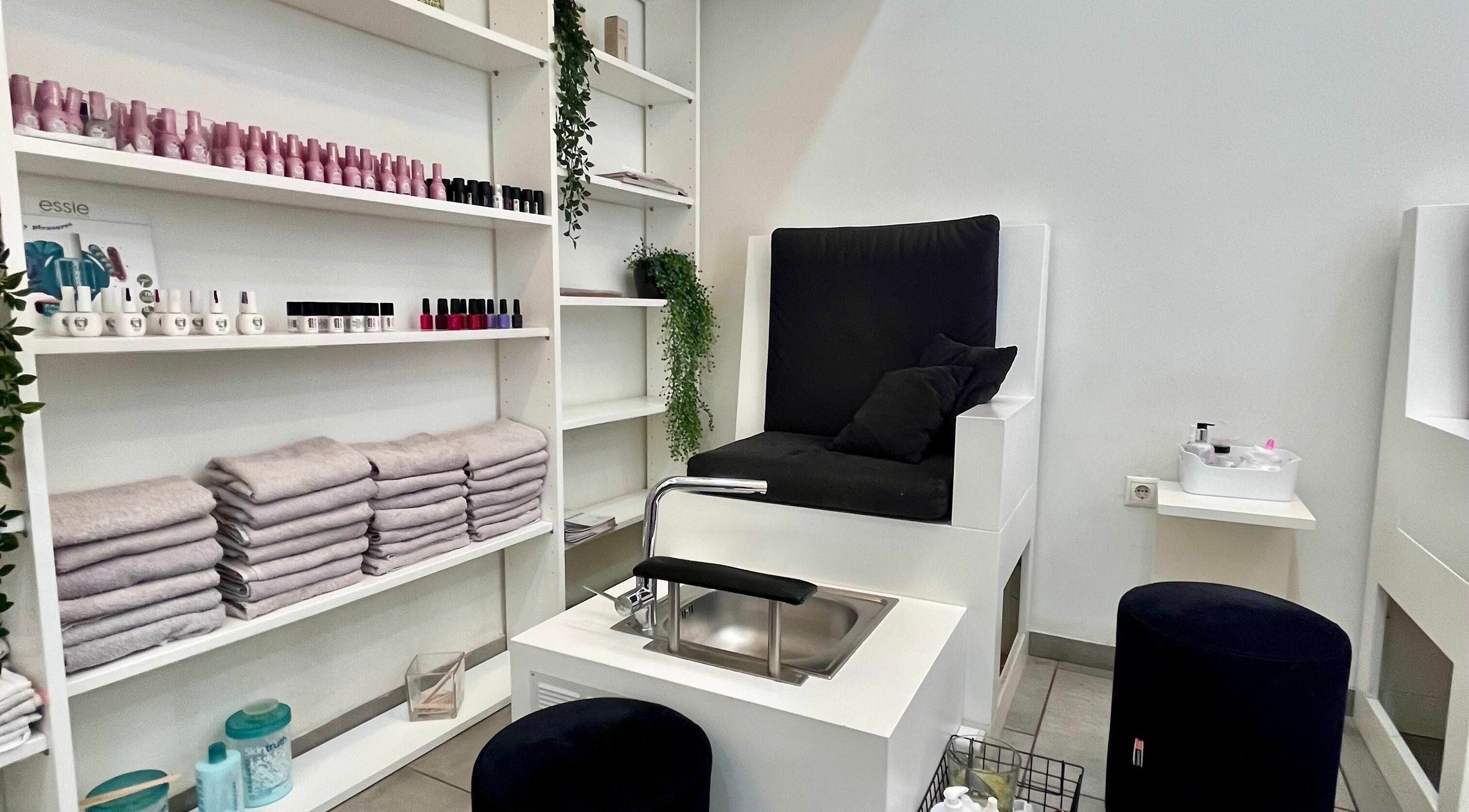 Καλαίσθητος χώρος μανικιούρ και πεντικιούρ στο Y2nails, Αθήνα, GR με κομψά έπιπλα και ποικιλία προϊόντων περιποίησης.