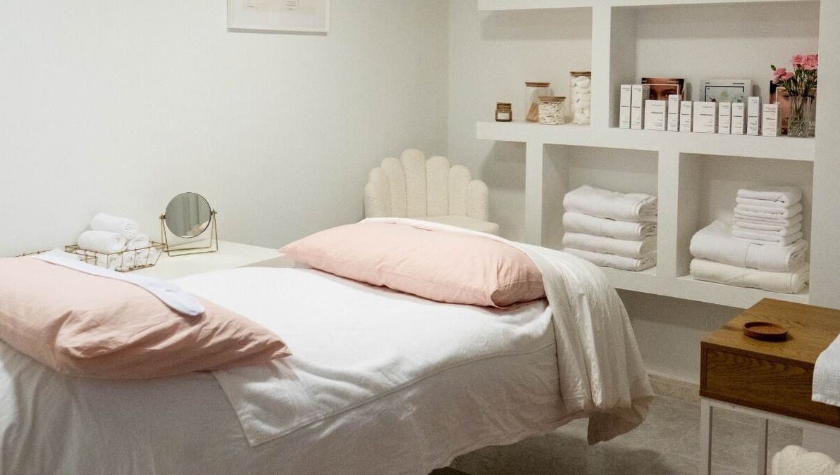 Cozy treatment room at Skin Studio By Elinor H, Palma, Illes Balears, ES with soft linens and organized shelves.