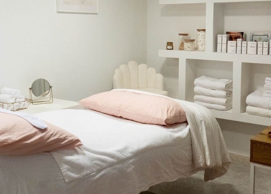 Cozy treatment room at Skin Studio By Elinor H, Palma, Illes Balears, ES with soft linens and organized shelves.