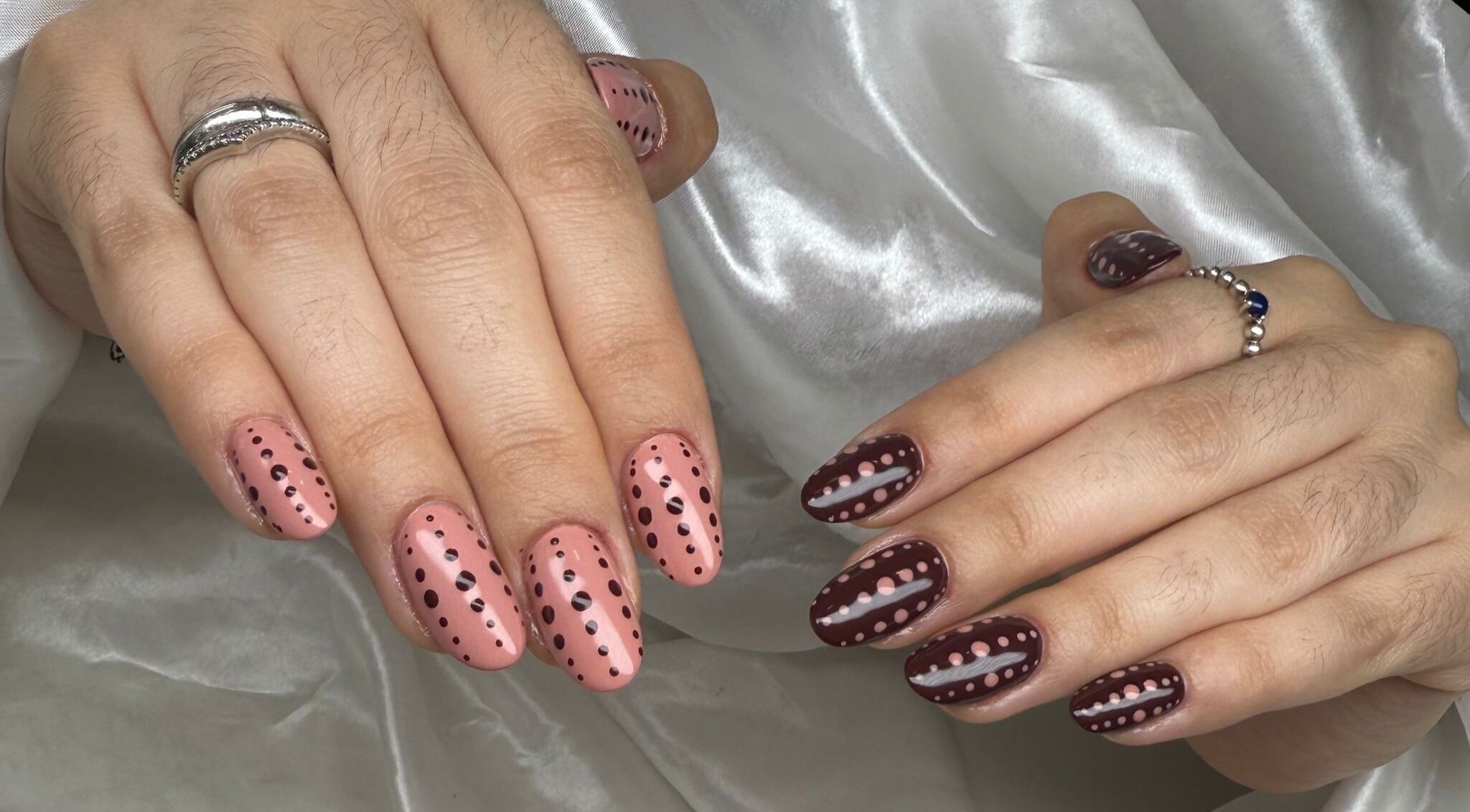 Stylish polka dot nail art at Malagó Beauty, Dublin, County Dublin, IE, on a silk fabric background.