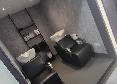 Modern wash stations at Salon Underground, Longridge, England, GB, featuring sleek chairs and stylish shelving.