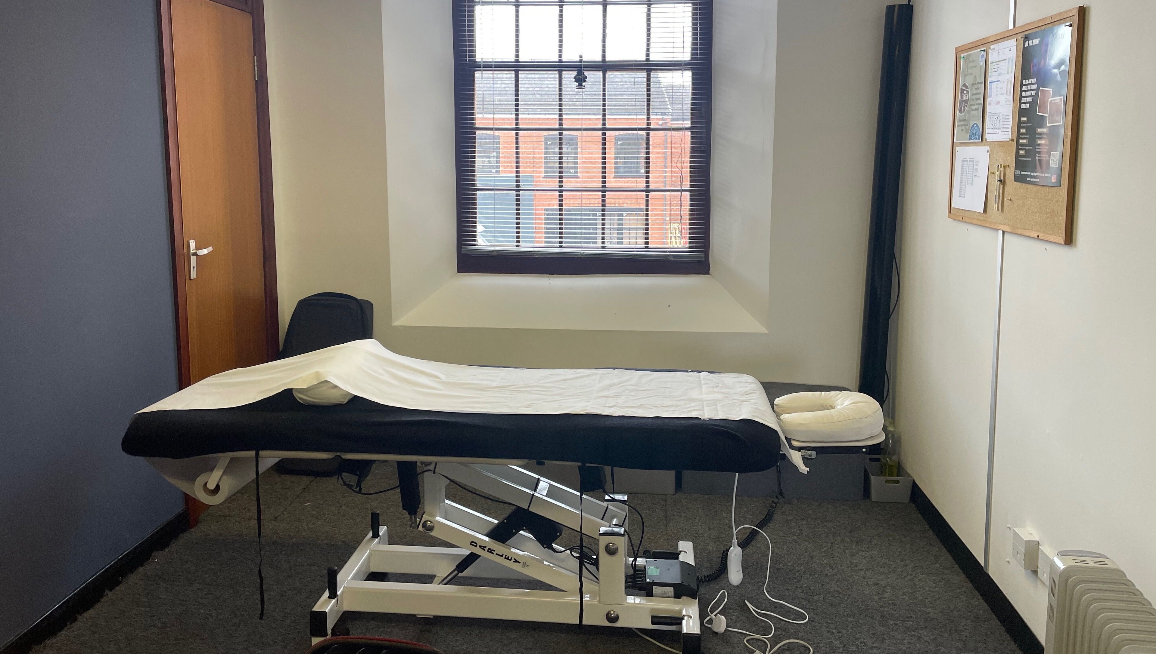 Relaxing spa room at Emerj Fit, Retford, England, GB. Features a massage table beneath a large window.