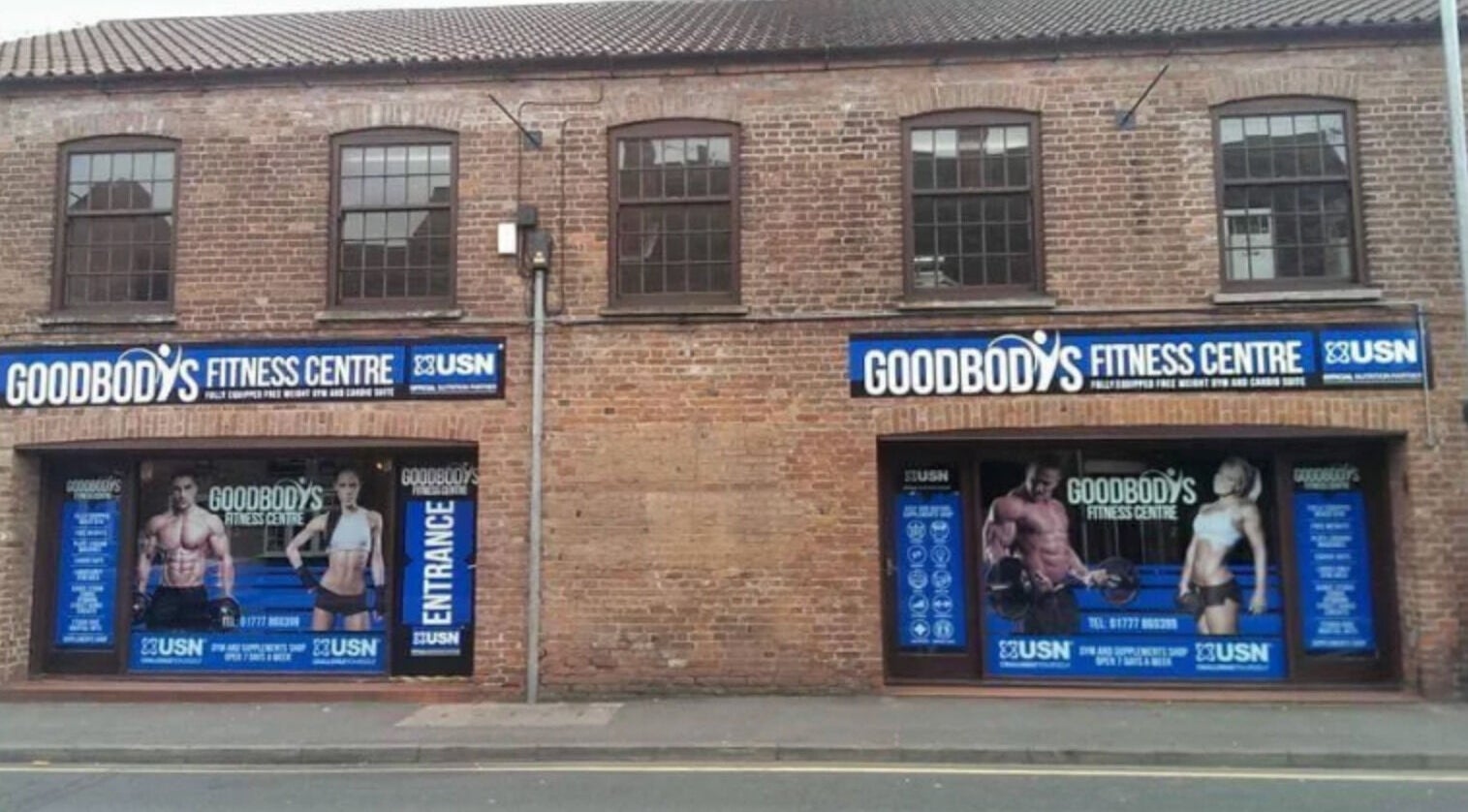 Emerj Fit entrance at Retford, England, GB, showcasing fitness posters on a brick building front.