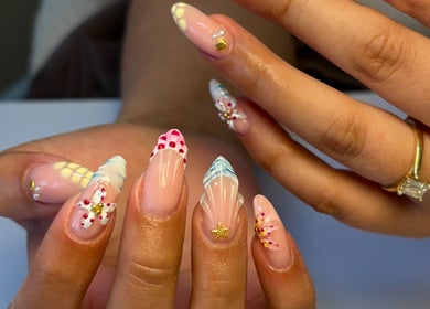 Intricate nail art at Atmillies, Scunthorpe, England, GB showcasing vibrant designs with jewelry accents.