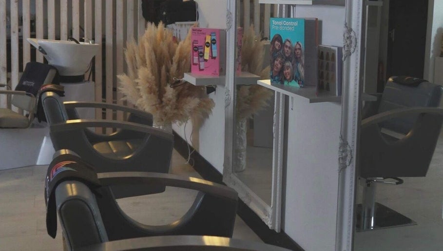 Interior of The White Hair salon in Barnsley, England, showcasing modern styling chairs and elegant decor.