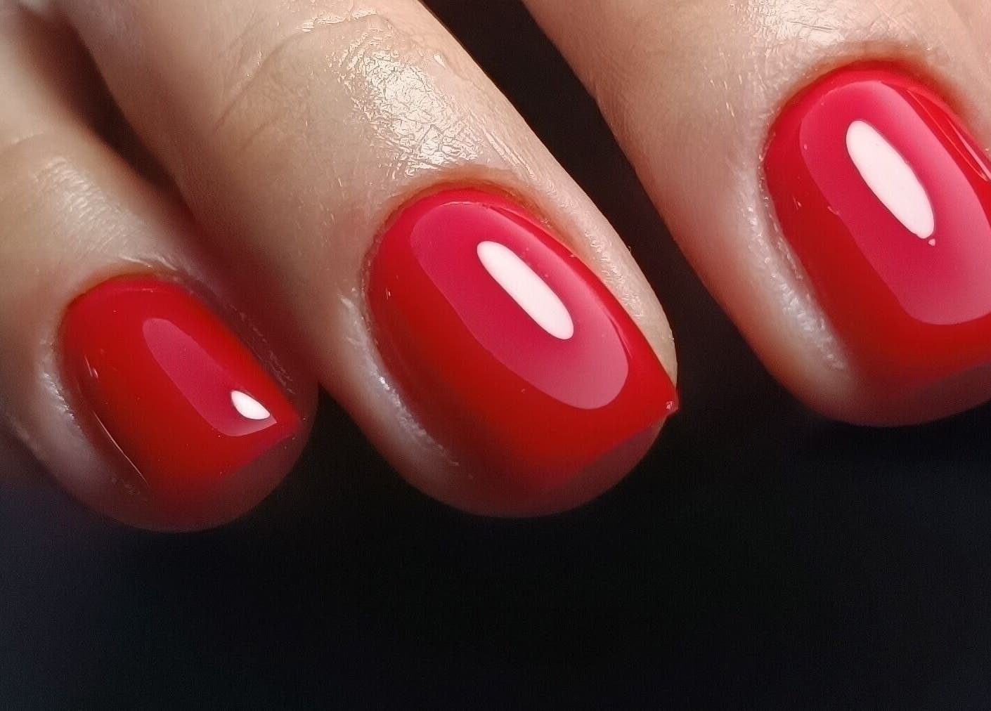 Diseño de uñas rojo vibrante en Nailsmetal, Envigado, Antioquia, CO, destacando brillo y perfección.