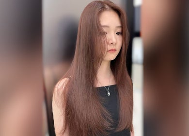 A woman with long, sleek hair styled at Cosmo Hair Salon, Melbourne, Victoria, AU.