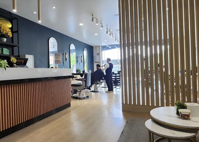 Modern interior of HILLMEN HAIR STUDIO AYER KEROH, Ayer Keroh, Melaka, MY, with stylish decor and client receiving a haircut.