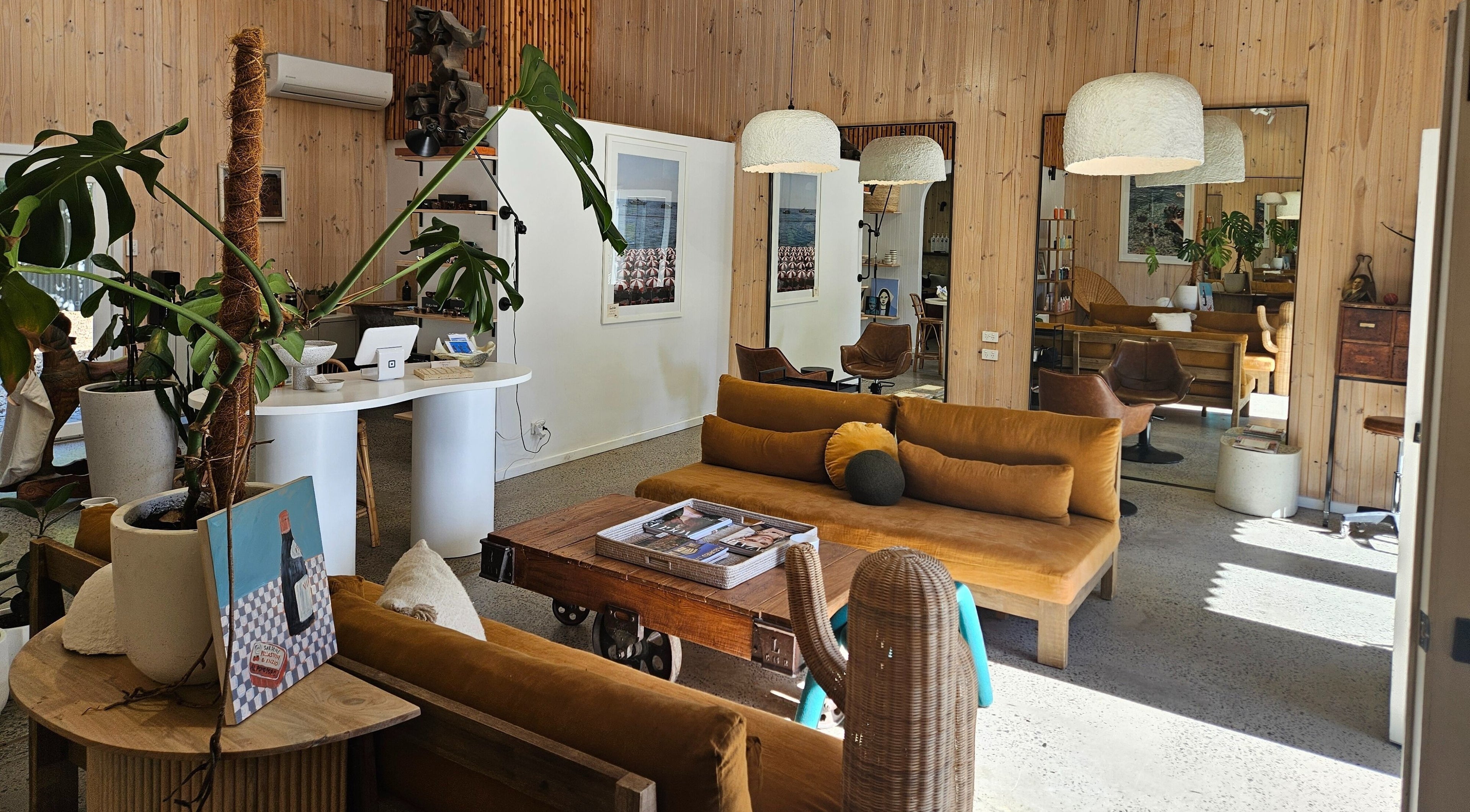 Chic interior of Asri Hair Salon, Port Elliot, South Australia, AU with modern decor and cozy seating area.