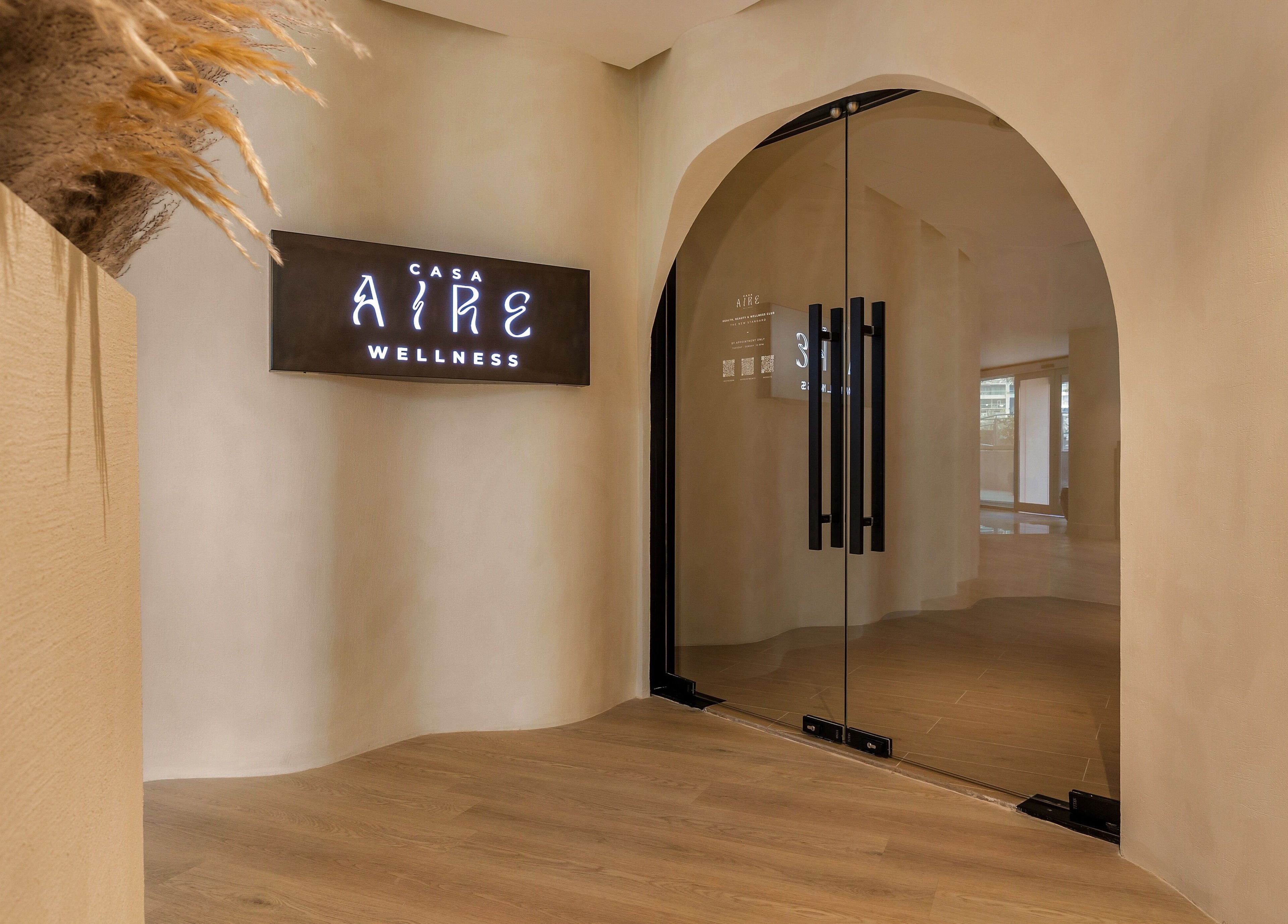 Elegant entrance of Aire MD by Casa Aire Wellness in Dubai, Dubai, AE, showcasing modern glass doors.