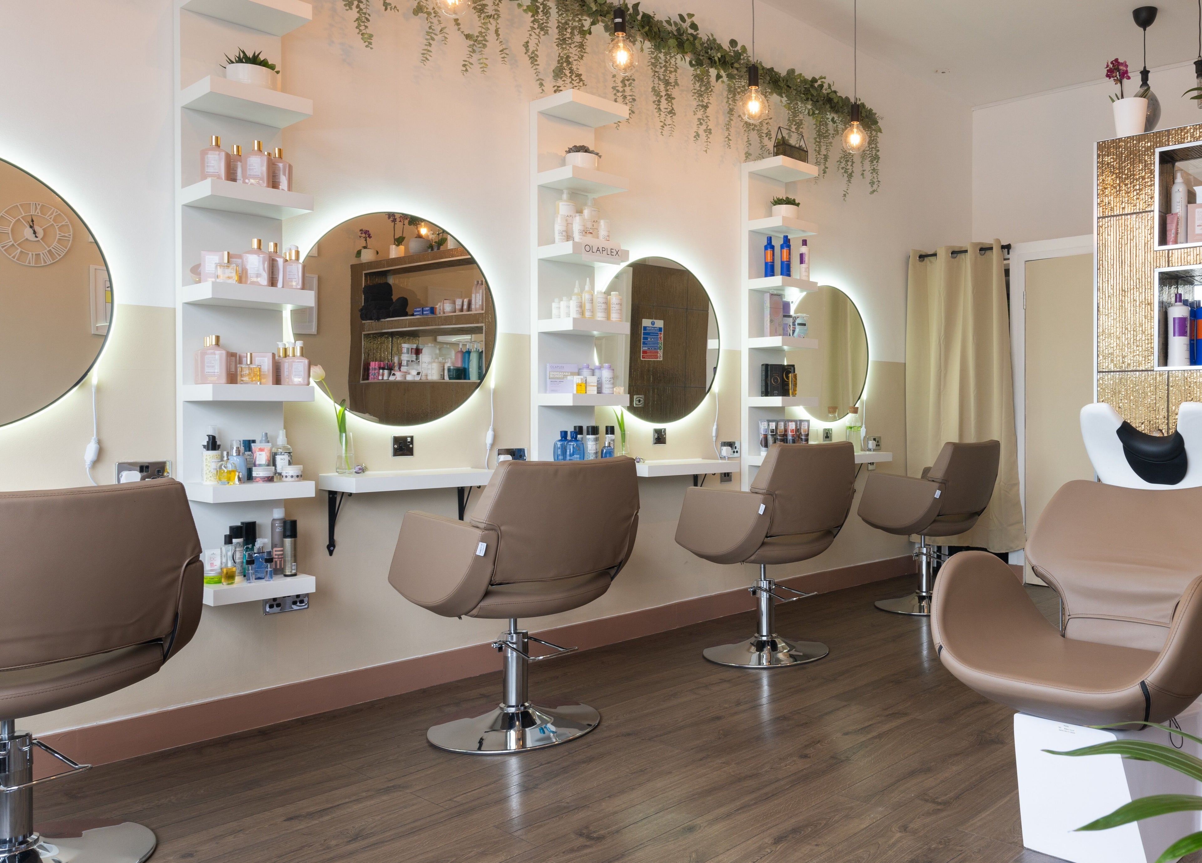 Elegant interior of Claudia Hairstylist in London, England, GB, showcasing contemporary salon chairs and mirrors.