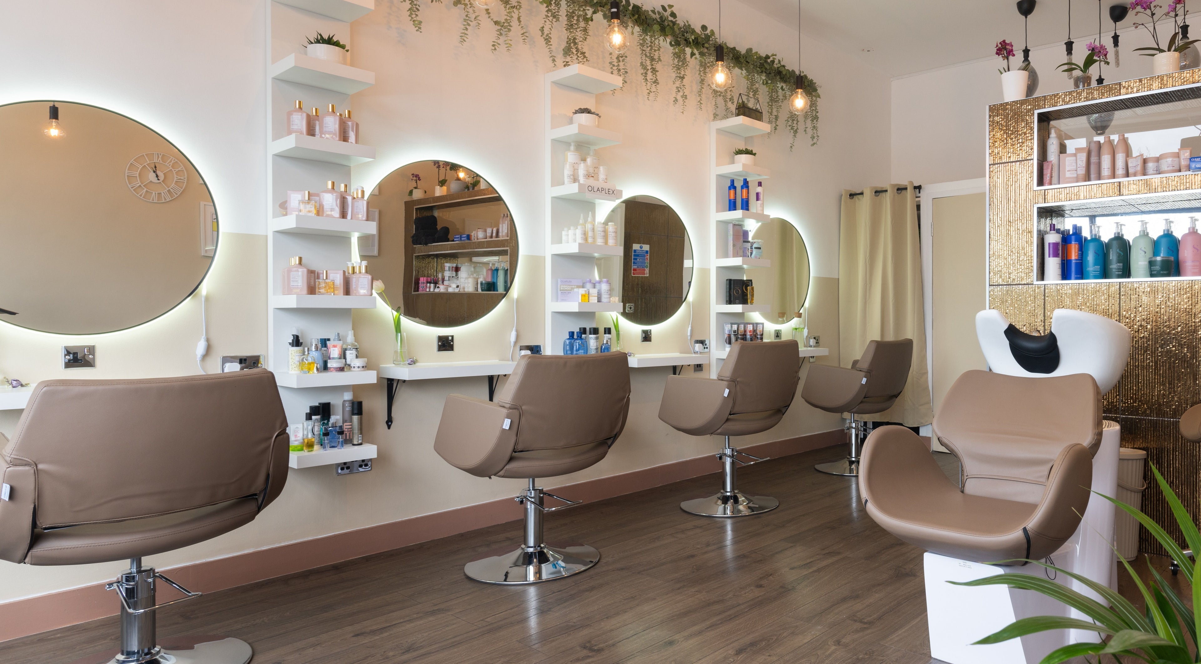 Elegant interior of Claudia Hairstylist in London, England, GB, showcasing contemporary salon chairs and mirrors.