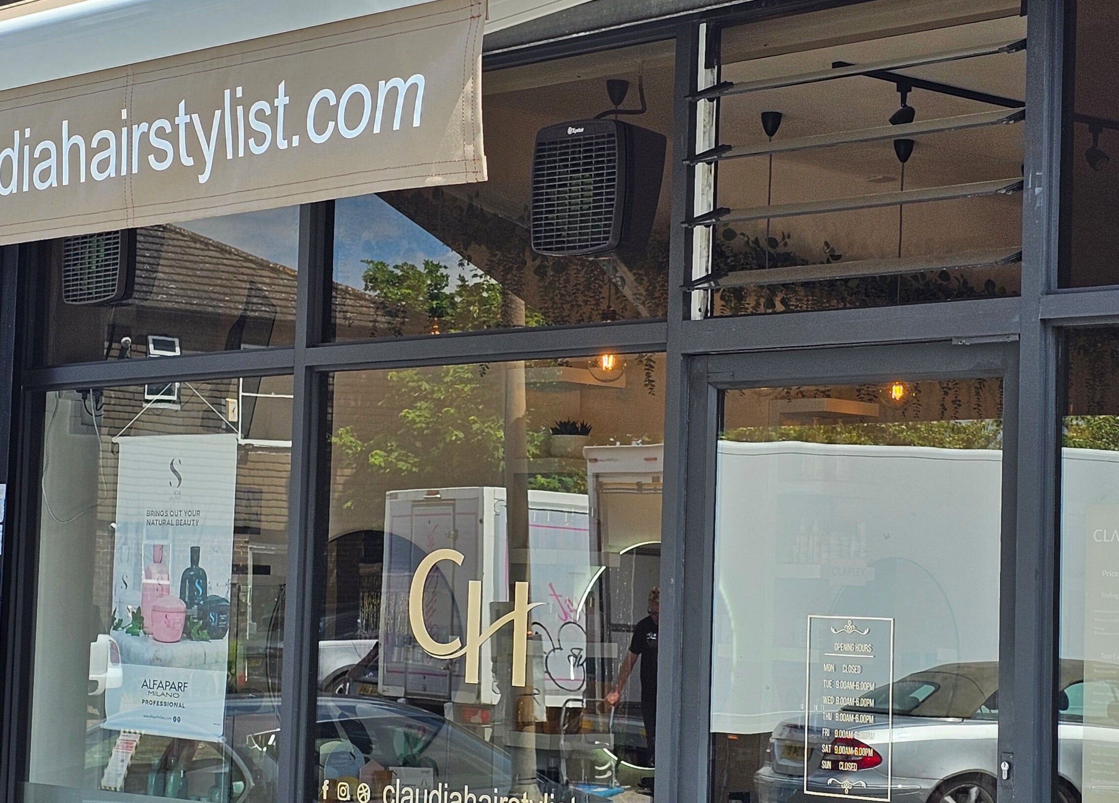 Front window of Claudia Hairstylist in London, England, GB showcasing sleek salon design.