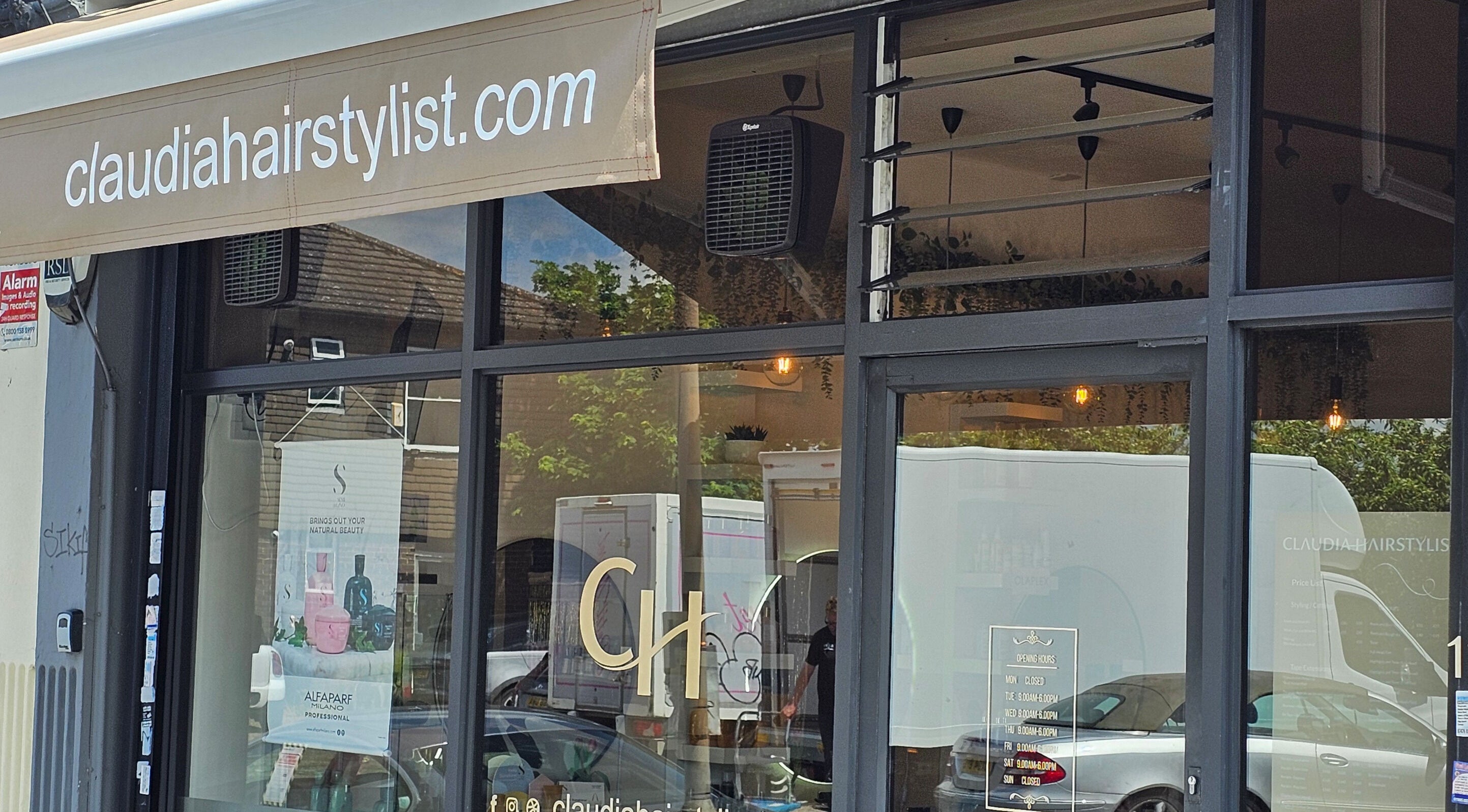 Front window of Claudia Hairstylist in London, England, GB showcasing sleek salon design.