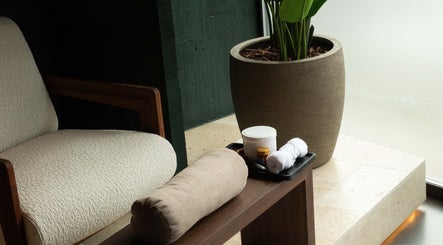 Coin détente élégant avec chaise et plante chez Bambou Massage à Uccle, Bruxelles, BE.